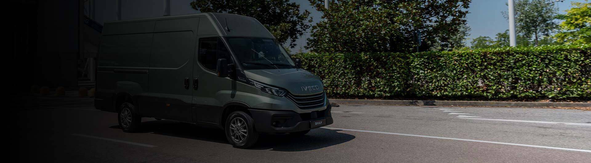 Samochód dostawczy Iveco Daily jadący drogą miejską – niezawodne rozwiązanie transportowe dla firm, idealne do codziennej pracy w biznesie