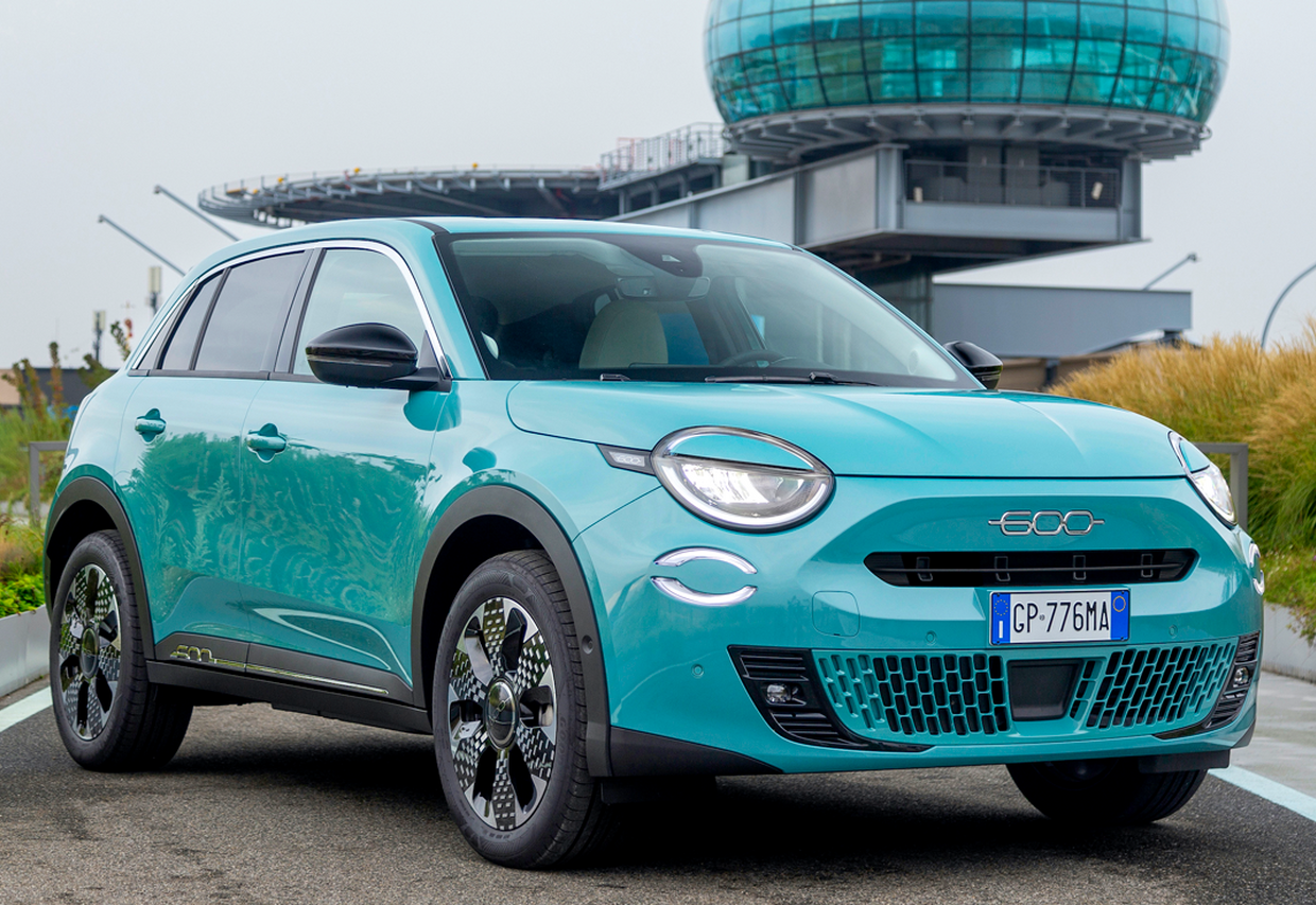 Fiat 600 Hybrid zaparkowany przed biurowcem – elegancki i technologiczny crossover
