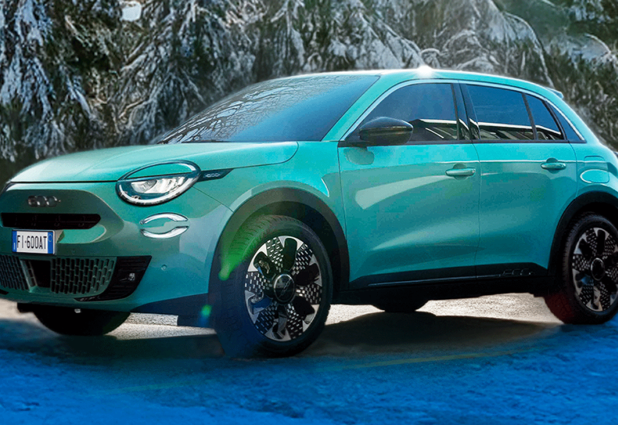 Fiat 600 Hybrid zaparkowany przed biurowcem – elegancki i technologiczny crossover